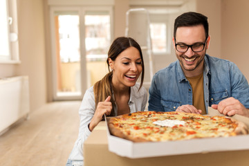 Happy couple eating pizza.