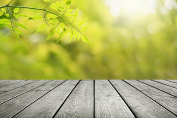 Naklejka na ściany i meble Wooden table and blurred leaf nature in garden background. 