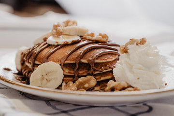 nata, banana, y nueces acompañados de pancake con chocolate