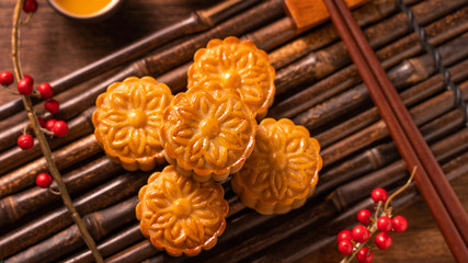 Moon cake Mooncake table setting - Chinese traditional pastry with tea cups on wooden background,...