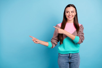 Photo of cheerful curious cunning interested teen lady looking to the side pointing on empty place...