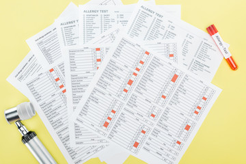 Obraz premium top view of allergy test results near test tube and dermatoscope isolated on yellow