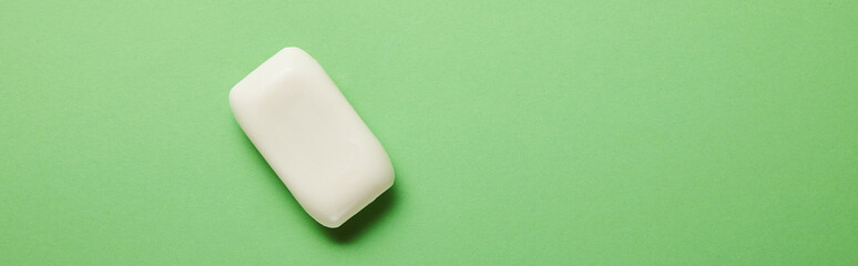panoramic shot of white soap on green background with copy space