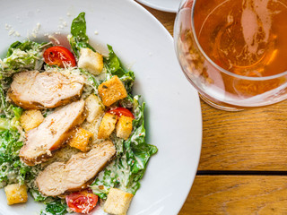 Chicken Salad. Chicken Caesar Salad. Caesar Salad with grilled chicken, lettuce, tomatoes and croutons and beer in glass
