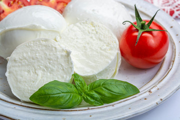 Italian soft cheese mozzarella, white cheese made from cow or buffalo milk with fresh green basil herb and red tomato