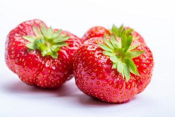 Three red ripe strawberries isolated on white background