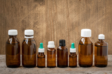 Row of  small bottles with medicinal solution on wooden background