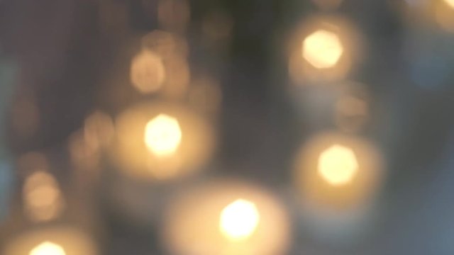 abstract background. burning decorative candles are on the floor. strong blur and defocus bokeh and glare.