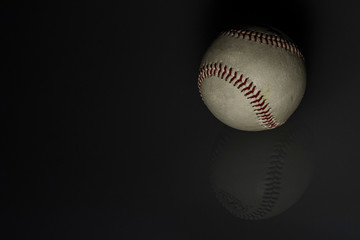 still life: old baseball ball in black background