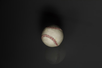 still life: old baseball ball in black background