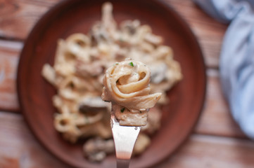 PPaste with cream sauce on a brown plateaste with cream sauce on a brown plate