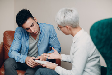 Consultation of young male patient on reception for psychologist. Advice concept.