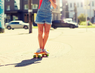 summer, extreme sport and people concept - teenage girl riding short modern cruiser skateboard on...