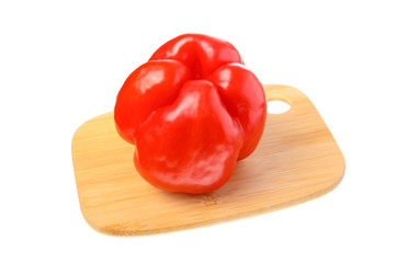 Single red peppers on cutting board