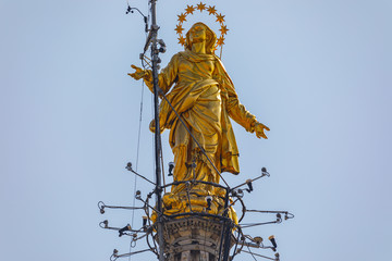 Obraz premium Closeup view on statue of the Madonna on the spire of Duomo