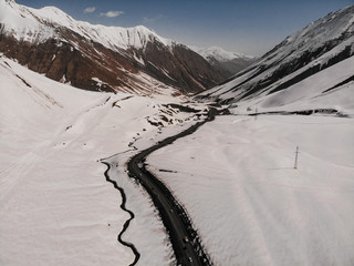 Drone shot of the country with snow on the mountains