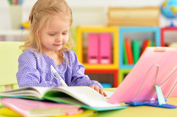 Cute teen girl doing homework in her room