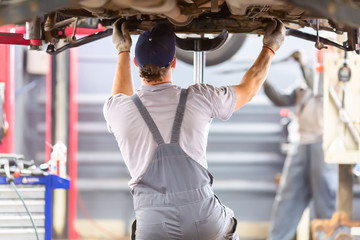 Car repair service. Mechanic working with a car in mechanical workshop