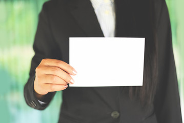Business woman hand mockup holding blank sheet of paper office working - young woman in suit shows white card Area for advertising white banner , business card or bonus