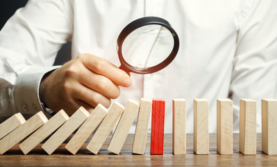 Businessman looks on collapse domino effect. Stress resistance business. Financial stability....