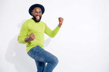Portrait of cheerful man with closed eyes raising fists screaming shouting yeah wearing eyeglasses...