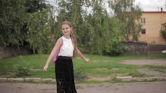 Young girl walking in the park with backpack