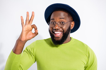 Portrait of funky person showing ok sign advertising promotion wearing green sweater isolated over white background