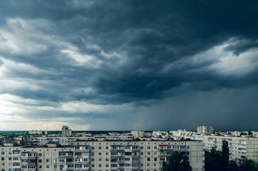 Fototapeta premium Dark storm clouds over houses, bad weather in the city
