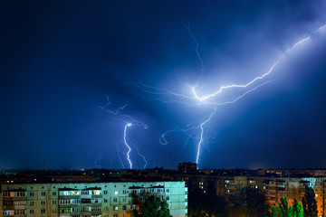 Naklejka na ściany i meble Thunderstorm with lightning and thunder over the night city