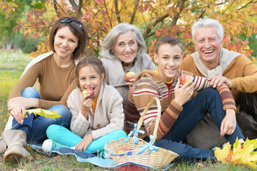 Portrait of happy beautiful smiling family relaxing in autumn park