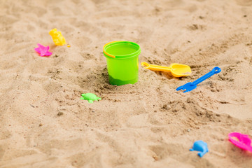 Fototapeta na wymiar childhood and summer concept - bucket and sand toys on beach or in sandbox