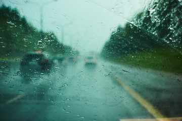 blurred view of road traffic on a rainy day through the car window