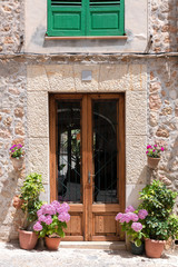 Obraz na płótnie Canvas Mallorca - House entrance with hydrangeas and green plants in Valldemossa