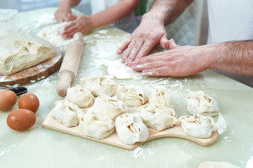 Uzbek national food manta, like dumplings, puts ingredients with a man's hand. selective control focus