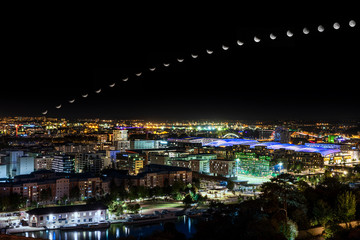 Fototapeta premium moon eclipse trajectory over the city at night