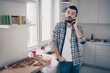 Portrait of his he nice attractive sad tired bored bearded guy talking on phone operator in modern...