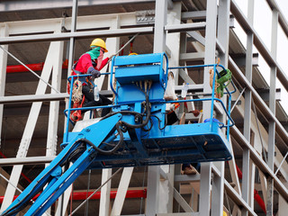 Construction worker at construction site using lifting boom machinery © dear2627