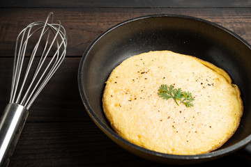 omelet in a pan on a wooden background.