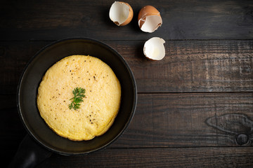 omelet in a pan on a wooden background.