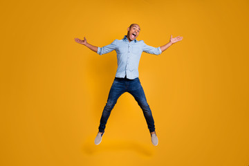 Fototapeta na wymiar Full length photo of charming boy raise hands air fly shout enjoy isolated over yellow background