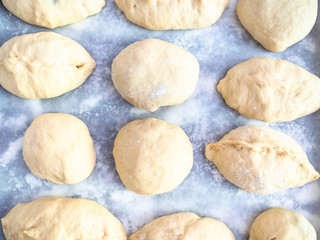 raw handmade sweet buns on baking paper