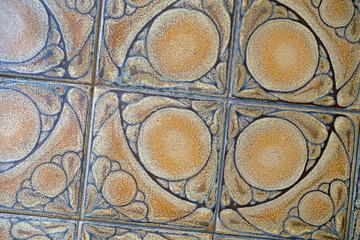Fragment of a floor from a ceramic tile. Brown ceramic tiles with a pattern.