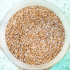 top view of broken wheat groats in glass jar