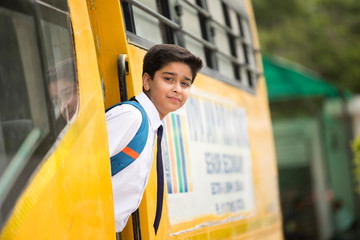 Indian schoolboy getting into the school bus