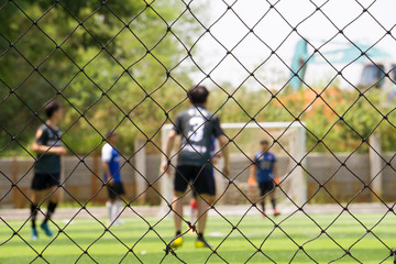 Close up Fence of artificial grass indoor football field for protect the ball over football field.