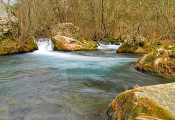 Long exposure photo of a stream with rocks, Lousios river in Peloponnese, Greece.