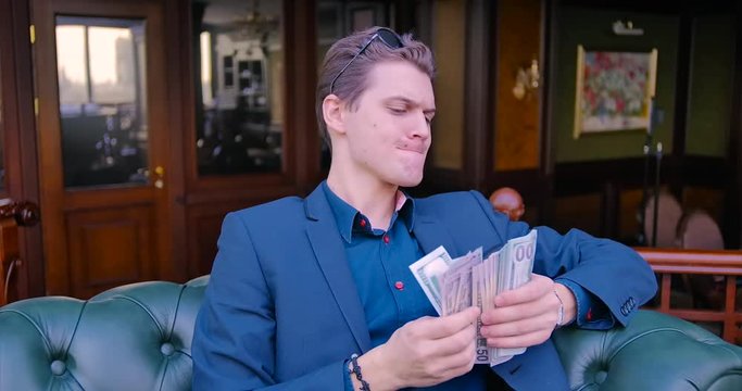 Young guy businessman freelancer counts money. Dollars, income, finance, business, suit