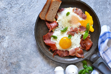 Classic breakfast - fried egg with bacon and bread. View from above.