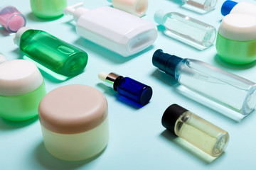 Top view of cosmetic products in different jars and bottles on blue background. Close-up of containers with copy space