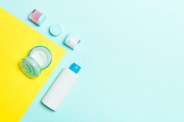 Group of plastic bodycare bottle Flat lay composition with cosmetic products on yellow and blue background empty space for you design. Set of White Cosmetic containers, top view with copy space